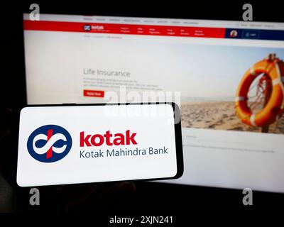 Stuttgart, Deutschland, 29.01.2023: Person, die ein Mobiltelefon mit dem Logo des indischen Finanzunternehmens Kotak Mahindra Bank auf dem Bildschirm vor dem Geschäft hält Stockfoto