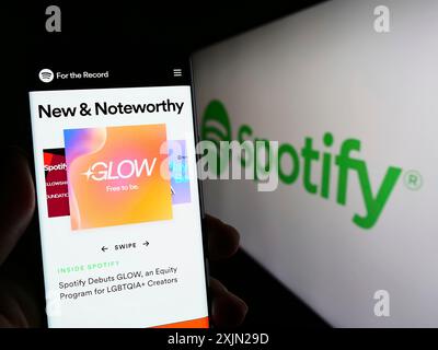 Stuttgart, Deutschland, 29.01.2023: Person, die ein Smartphone hält, mit Website des Musikstreamingunternehmens Spotify Technology S.A. auf dem Bildschirm mit Logo. Fokus Stockfoto