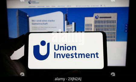 Stuttgart, Deutschland, 29.01.2023: Person, die ein Smartphone mit dem Logo der deutschen Investmentgesellschaft Union Investment auf dem Bildschirm vor der Website hält. Stockfoto