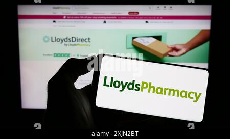 Stuttgart, Deutschland, 03.07.2023: Person mit Mobiltelefon mit Logo des britischen Unternehmens LloydsPharmacy Limited auf dem Bildschirm vor der Website des Unternehmens. Stockfoto