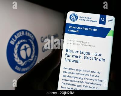 Stuttgart, Deutschland, 03-11-2023: Person, die ein Handy hält, mit Website des deutschen Umweltzeichens Blauer Engel auf dem Bildschirm. Konzentrieren Sie sich auf Stockfoto