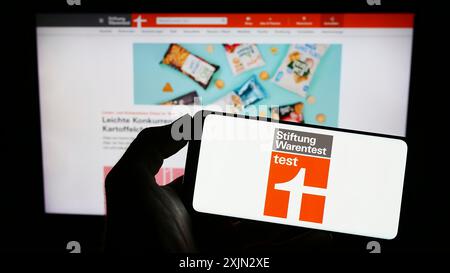 Stuttgart, Deutschland, 03-10-2023: Person mit Handy mit Logo der Stiftung Warentest auf dem Bildschirm vor der Webseite. Stockfoto