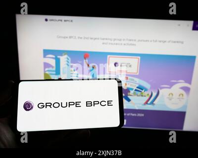 Stuttgart, Deutschland, 13.03.2023: Person, die ein Smartphone mit dem Logo der französischen Bankgesellschaft Groupe BPCE auf dem Bildschirm vor der Website hält. Konzentrieren Sie sich auf Stockfoto