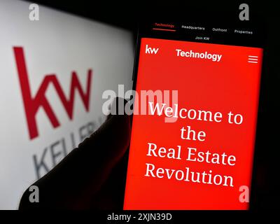 Stuttgart, Deutschland, 13.03.2023: Person, die ein Handy hält, mit Webseite der Immobiliengesellschaft Keller Williams Realty Inc. Auf dem Bildschirm mit Logo. Fokus Stockfoto