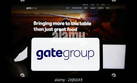 Stuttgart, Deutschland, 13.03.2023: Person mit Smartphone mit Logo der Schweizer Gastronomie Gategroup Holding AG auf dem Bildschirm vor der Website. Stockfoto
