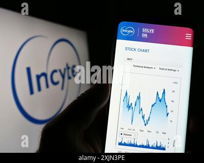 Stuttgart, Deutschland, 22.03.2023: Person, die ein Smartphone hält, mit der Webseite des US-Pharmaunternehmens Incyte Corporation auf dem Bildschirm mit Logo. Konzentrieren Sie sich auf Stockfoto