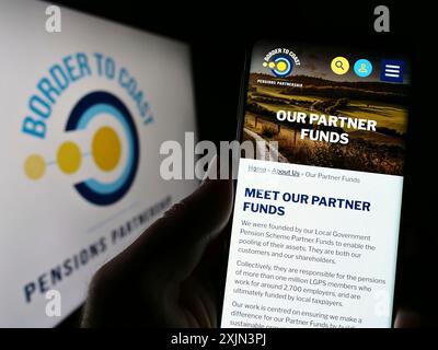 Stuttgart, Deutschland, 22.03.2023: Person, die ein Smartphone hält, mit Webseite der British Border to Coast Pensions Partnership auf dem Bildschirm mit Logo. Konzentrieren Sie sich auf Stockfoto