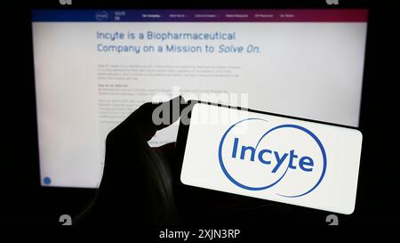 Stuttgart, Deutschland, 22.03.2023: Person, die ein Smartphone mit dem Logo des US-Pharmaunternehmens Incyte Corporation auf dem Bildschirm vor der Website hält. Stockfoto