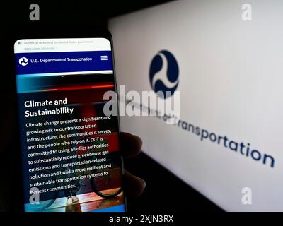 Stuttgart, Deutschland, 22.03.2023: Person, die ein Mobiltelefon hält, mit Webseite des US-Verkehrsministeriums (USDOT) auf dem Bildschirm mit Logo. Stockfoto