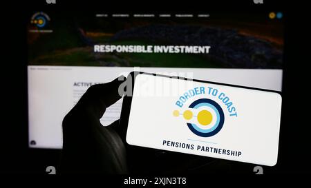 Stuttgart, 22.03.2023: Person, die ein Mobiltelefon mit dem Logo der British Border to Coast Pensions Partnership auf dem Bildschirm vor der Webseite hält. Stockfoto