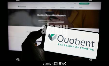 Stuttgart, Deutschland, 19.03.2023: Person, die ein Mobiltelefon mit dem Logo der amerikanischen Marketingfirma Quotient Technology Inc. Auf dem Bildschirm hält Stockfoto