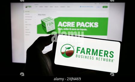 Stuttgart, Deutschland, 03-31-2023: Person mit Handy mit Logo der Landwirtschafts-Plattform Farmers Business Network (FBN) auf dem Bildschirm vor Stockfoto