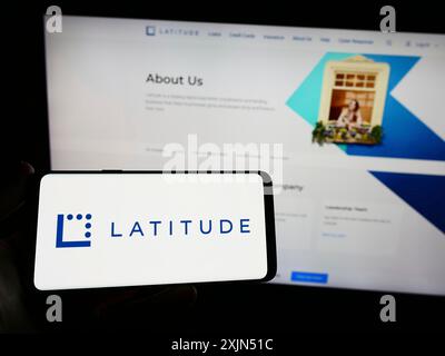 Stuttgart, Deutschland, 23.04.2023: Person, die ein Smartphone mit dem Logo des australischen Finanzunternehmens Latitude Group auf dem Bildschirm vor der Website hält. Stockfoto