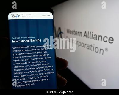 Stuttgart, 24.04.2023: Person, die ein Smartphone mit dem Logo des US-amerikanischen Unternehmens Western Alliance Bancorporation auf dem Bildschirm vor der Website hält. Stockfoto