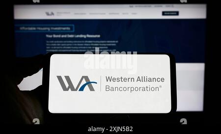 Stuttgart, 24.04.2023: Person, die ein Smartphone mit dem Logo des US-amerikanischen Unternehmens Western Alliance Bancorporation auf dem Bildschirm vor der Website hält. Stockfoto