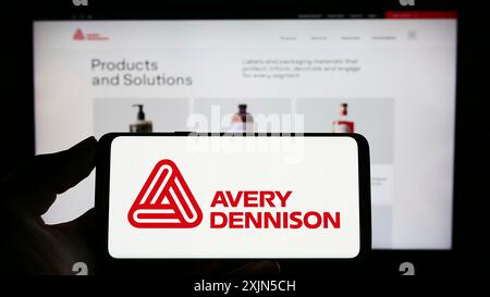 Stuttgart, Deutschland, 28.04.2023: Person, die ein Mobiltelefon mit dem Logo des amerikanischen Verpackungsunternehmens Avery Dennison Corporation auf dem Bildschirm hält Stockfoto