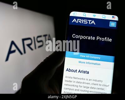 Stuttgart, Deutschland, 28.04.2023: Person, die ein Mobiltelefon hält, mit Webseite des Computernetzwerks Arista Networks Inc. Auf dem Bildschirm mit Logo. Fokus Stockfoto