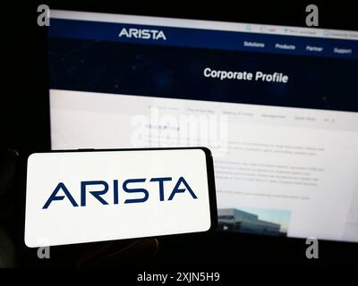 Stuttgart, Deutschland, 28.04.2023: Person, die ein Smartphone hält, mit dem Logo des Netzwerkanbieters Arista Networks Inc. Auf dem Bildschirm vor dem Gerät Stockfoto