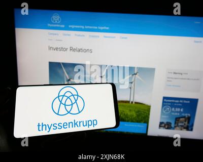 Stuttgart, Deutschland, 03-31-2023: Handybesitzer mit Logo des deutschen Konzerns ThyssenKrupp AG auf dem Bildschirm vor der Business-Website. Stockfoto
