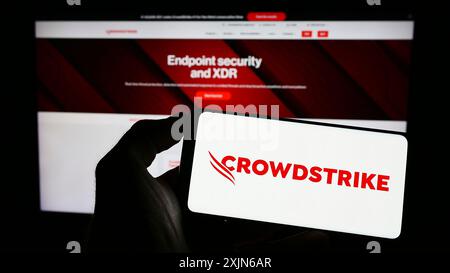 Stuttgart, Deutschland, 03-31-2023: Person, die ein Smartphone mit dem Logo des Cybersicherheitsunternehmens CrowdStrike Holdings Inc. Auf dem Bildschirm vor der Website hält. Stockfoto