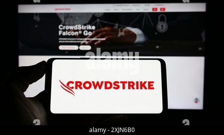 Stuttgart, Deutschland, 03-31-2023: Person, die ein Mobiltelefon mit dem Logo des Cybersicherheitsunternehmens CrowdStrike Holdings Inc. Auf dem Bildschirm vor der Webseite hält. Stockfoto