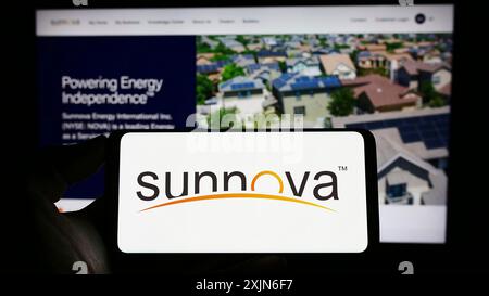Stuttgart, 25.03.2023: Person, die ein Mobiltelefon mit dem Logo des amerikanischen Unternehmens Sunnova Energy International Inc. Auf dem Bildschirm hält Stockfoto