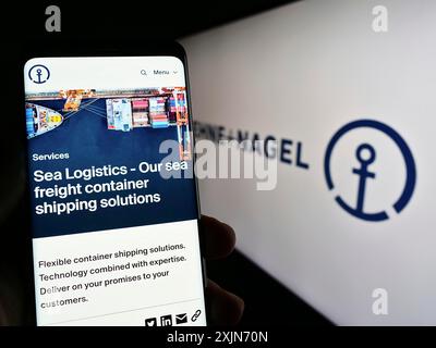 Stuttgart, 25.03.2023: Handybesitzer mit Webseite des Logistikunternehmens Kuehne Nagel International AG auf dem Bildschirm mit Logo. Fokus Stockfoto
