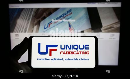 Stuttgart, Deutschland, 19.03.2023: Person, die ein Smartphone mit dem Logo des US-amerikanischen Herstellers Unique Fabricating Inc. Auf dem Bildschirm hält Stockfoto