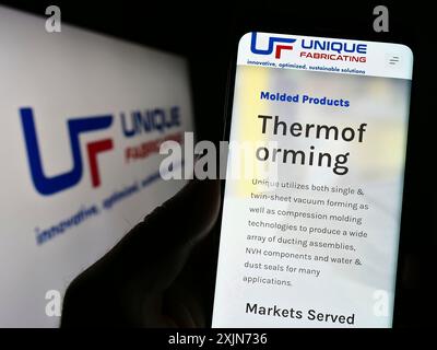 Stuttgart, Deutschland, 19.03.2023: Person, die ein Smartphone hält, mit der Webseite des US-amerikanischen Herstellers Unique Fabricating Inc. Auf dem Bildschirm mit Logo. Fokus Stockfoto