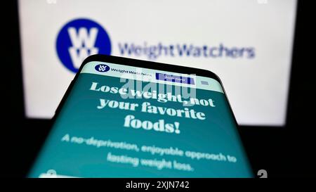 Stuttgart, Deutschland, 19.03.2023: Smartphone mit Website von WW International Inc. (Weight Watchers) auf dem Bildschirm vor dem Business-Logo. Konzentrieren Sie sich auf Stockfoto