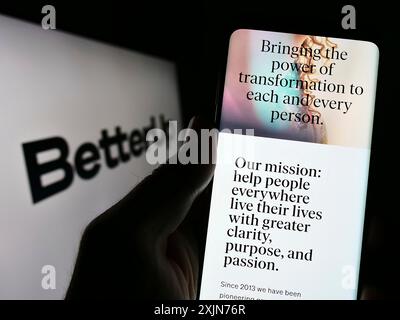 Stuttgart, Deutschland, 26.03.2023: Person, die ein Mobiltelefon hält, mit Webseite des US-Coaching-Unternehmens BetterUp vor dem Firmenlogo. Konzentrieren Sie sich auf Stockfoto