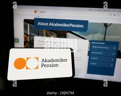 Stuttgart, Deutschland, 04.01.2023: Person mit Mobiltelefon mit Logo der dänischen Pensionskasse AkademikerPension auf dem Bildschirm vor der Webseite des Unternehmens. Stockfoto