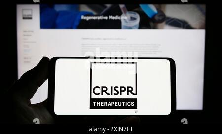 Stuttgart, Deutschland, 21.04.2023: Person mit Smartphone mit Logo des Biotechnologie-Unternehmens CRISPR Therapeutics AG auf dem Bildschirm vor der Website. Stockfoto