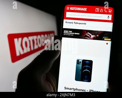 Stuttgart, 24.06.2023: Person, die ein Smartphone hält, mit der Webseite des griechischen Elektronikeinzelhandelsunternehmens Kotsovolos auf dem Bildschirm mit Logo. Konzentrieren Sie sich auf Stockfoto