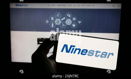 Stuttgart, Deutschland, 18.06.2023: Person, die ein Smartphone mit dem Logo der chinesischen Druckerfirma Ninestar Corporation auf dem Bildschirm vor der Website hält. Stockfoto