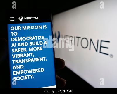 Stuttgart, Deutschland, 18.06.2023: Person, die ein Smartphone hält, mit Webseite des US-amerikanischen Unternehmens Veritone Inc. Auf dem Bildschirm mit Logo. Stockfoto