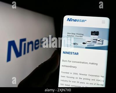 Stuttgart, Deutschland, 18.06.2023: Person, die ein Mobiltelefon hält, mit Website der chinesischen Druckerfirma Ninestar Corporation auf dem Bildschirm mit Logo. Konzentrieren Sie sich auf Stockfoto