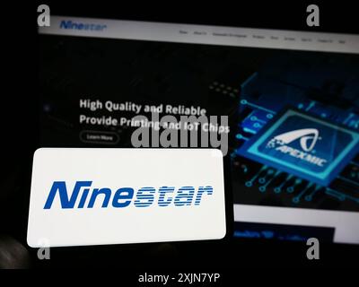 Stuttgart, Deutschland, 18.06.2023: Person, die ein Mobiltelefon mit dem Logo der chinesischen Druckerfirma Ninestar Corporation auf dem Bildschirm vor der Webseite hält. Stockfoto