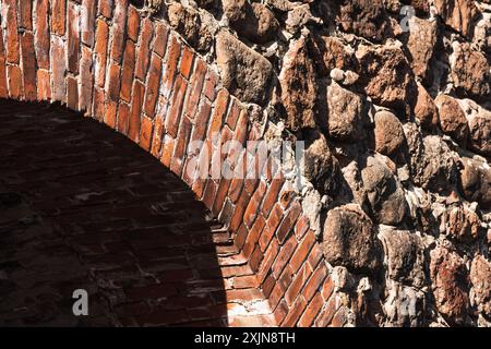 Klassischer architektonischer Hintergrund, Fragment einer Backsteinmauer und Bogen einer alten Burg Stockfoto