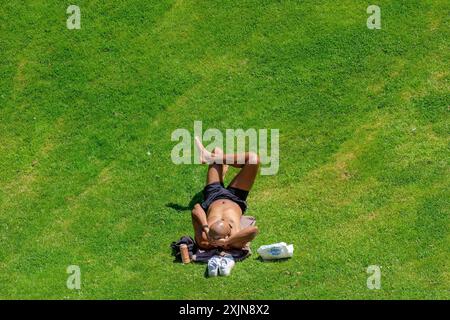 Bath, Großbritannien, 19. Juli 2024. Während Bath einen weiteren sehr heißen und sonnigen Tag genießt, wird ein Mann in den Parade Gardens sonnen. Quelle: Lynchpics/Alamy Live News Stockfoto