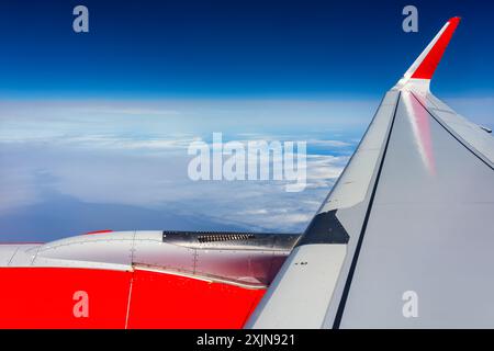 Panoramablick auf den Flügel und Motor eines Flugzeugs, während ein Wolkenmeer über dem Ozean fliegt, Kanarische Inseln. Stockfoto