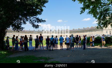 Bath, Großbritannien, 19. Juli 2024. Viele Teile Englands und Wales erleben warme Temperaturen von 31 °C. Touristen vor dem weltberühmten Royal Crescent werden im Bild eines Reiseleiters über den berühmten Crescent erzählt. Quelle: Lynchpics/Alamy Live News Stockfoto