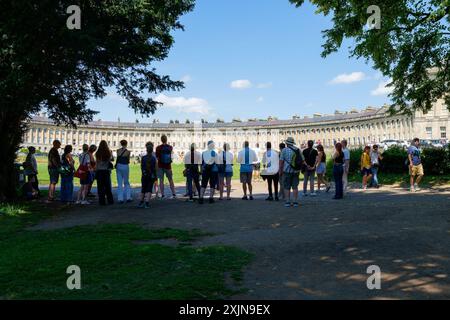 Bath, Großbritannien, 19. Juli 2024. Viele Teile Englands und Wales erleben warme Temperaturen von 31 °C. Touristen vor dem weltberühmten Royal Crescent werden im Bild eines Reiseleiters über den berühmten Crescent erzählt. Quelle: Lynchpics/Alamy Live News Stockfoto
