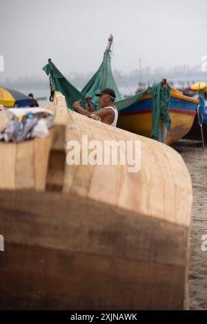 Lima - Peru, 21. Mai 2023 - in Limas belebtem Fischerhafen werden Fischer beim Reparieren von Netzen und beim Vorbereiten von Booten beobachtet Stockfoto