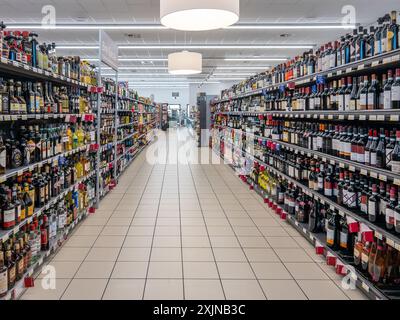 Italien - 19. Juni 2024: Wein- und Spirituosengang mit Regalen mit Flaschen Wein und Bier sowie Spirituosen verschiedener Art und Marken zum Verkauf in Stockfoto