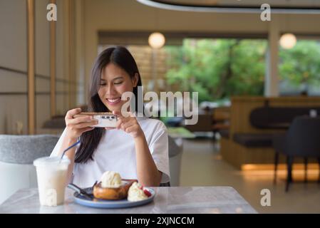 Junge Thailändische Frau genießt Dessert im Coffee Shop Konzept Stockfoto