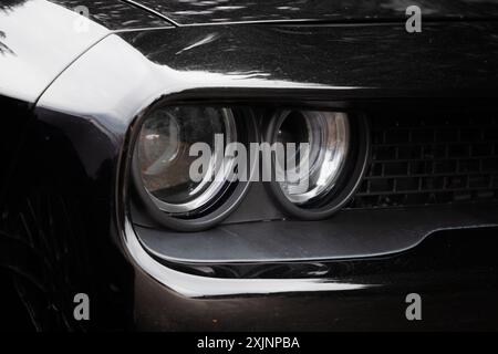 Die markanten Frontscheinwerfer des Dodge Challenger mit ihrem auffälligen Design und der intensiven Beleuchtung begeistern das Publikum im amerikanischen Car Sho Stockfoto