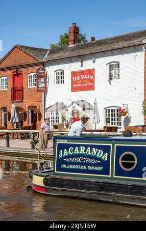 Canal Narrowboat liegt vor dem Swan inn Public House am Trent and Mersey Kanal an der Fradley Junction zwischen Alrewas und Fradley Staffordshire Stockfoto