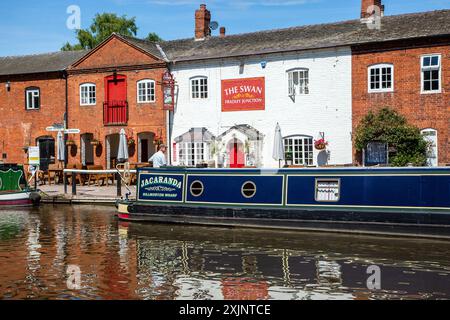 Canal Narrowboat liegt vor dem Swan inn Public House am Trent and Mersey Kanal an der Fradley Junction zwischen Alrewas und Fradley Staffordshire Stockfoto