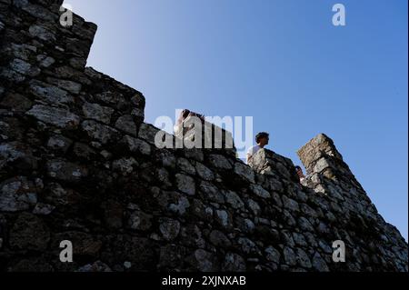 Menschen gegen den blauen Himmel auf den Steinmauern der maurischen Burg in Sintra Stockfoto